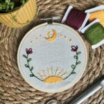 Broderie décorative : motif équinoxe, soleil, lune, végétaux.