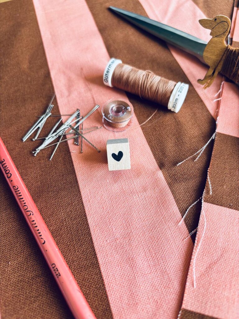 Matériel de couture: aiguilles, tissu, fils, ciseaux.