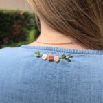 Ensemble de roses brodées sur le col arrière d'une robe en jeans.