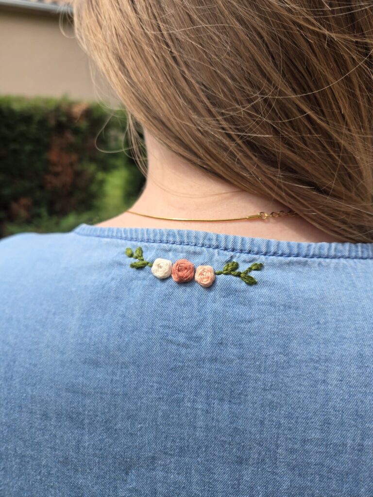 Ensemble de roses brodées sur le col arrière d'une robe en jeans.
