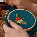 Main qui brode un motif décoratif : Appareil photo fleuri