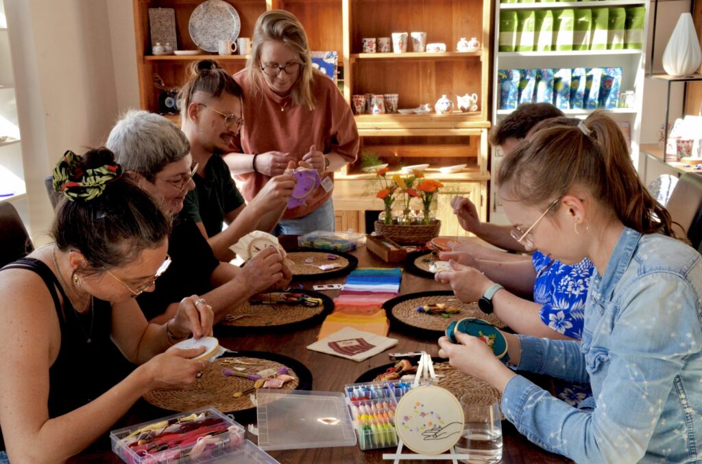 Un groupe de personnes qui brodent une broderie décorative.